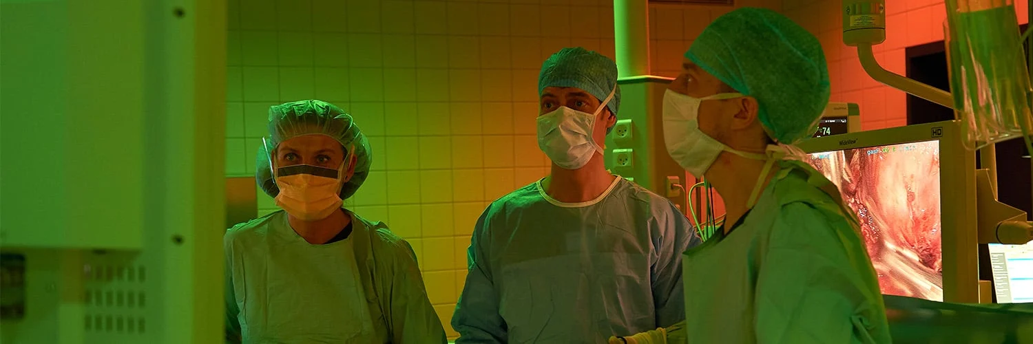 Hastane ameliyathanesinde insan odaklı ve ergonomik aydınlatma altında operasyon gerçekleştiren cerrahlar