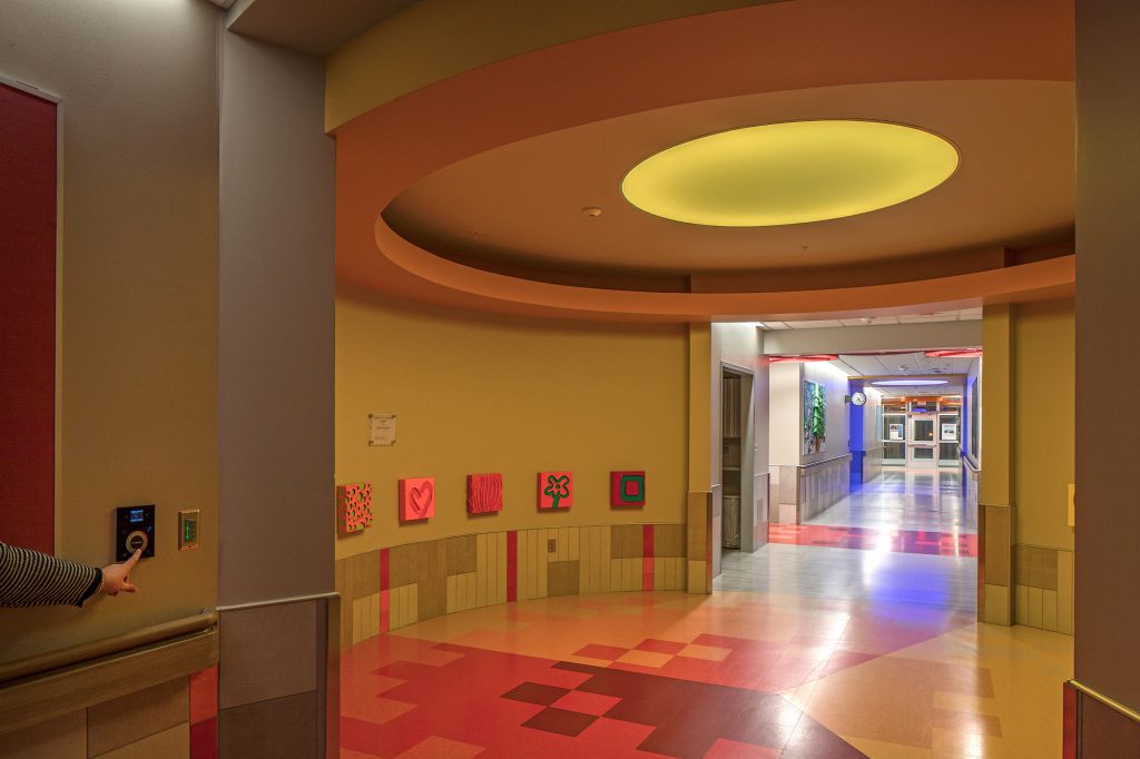 Eğitim kurumunda insan odaklı aydınlatma tasarımı örneği, renkli koridor ve dinamik tavan ışığı